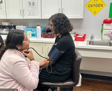 medical assistant student training with their instructor to take vitals