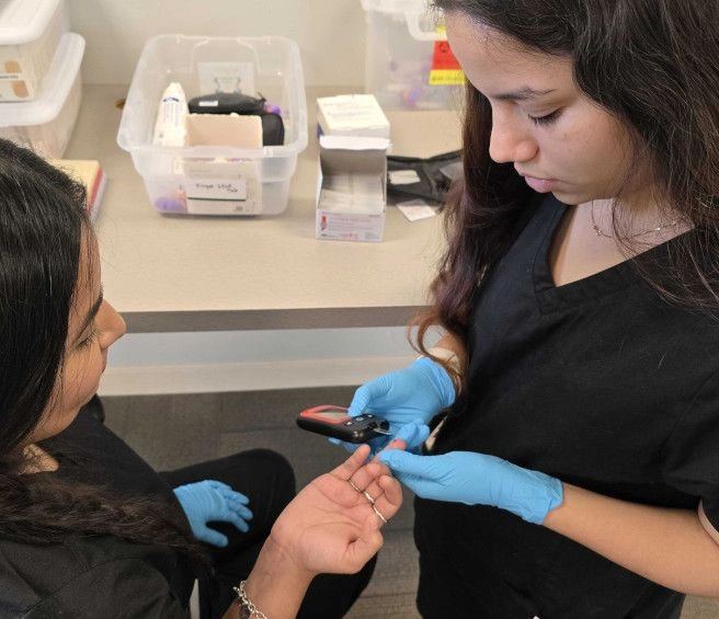 student training to take blood from a finger prick
